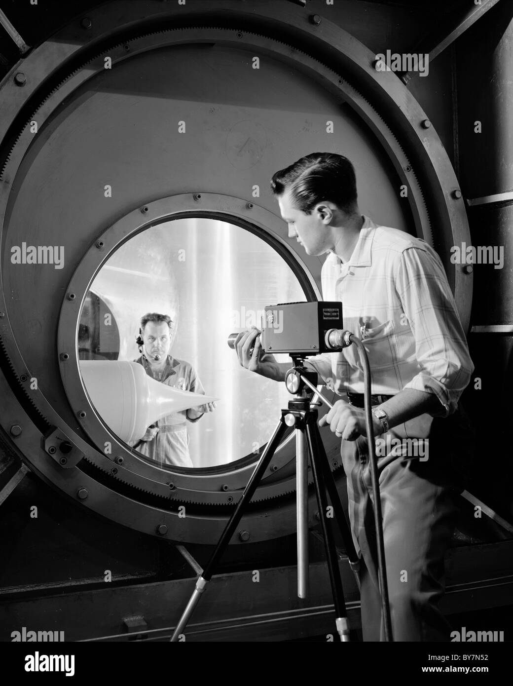 A television camera is focused by NACA technician on a ramjet engine at the Lewis Flight Propulsion Laboratory. Stock Photo