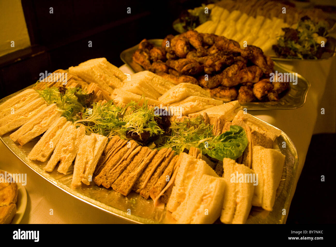 buffet food chicken drumsticks sandwiches Stock Photo