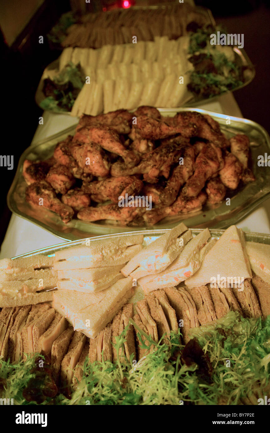 Food buffet on table in pub chicken drumsticks sandwiches Stock Photo