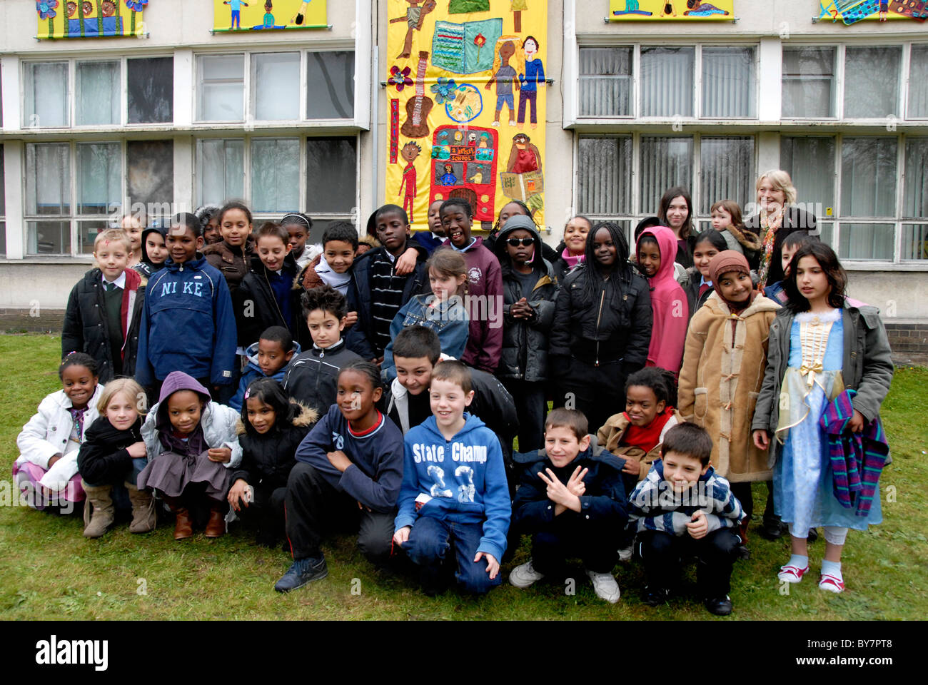 Mixed age group of junior school children assembled in front of school