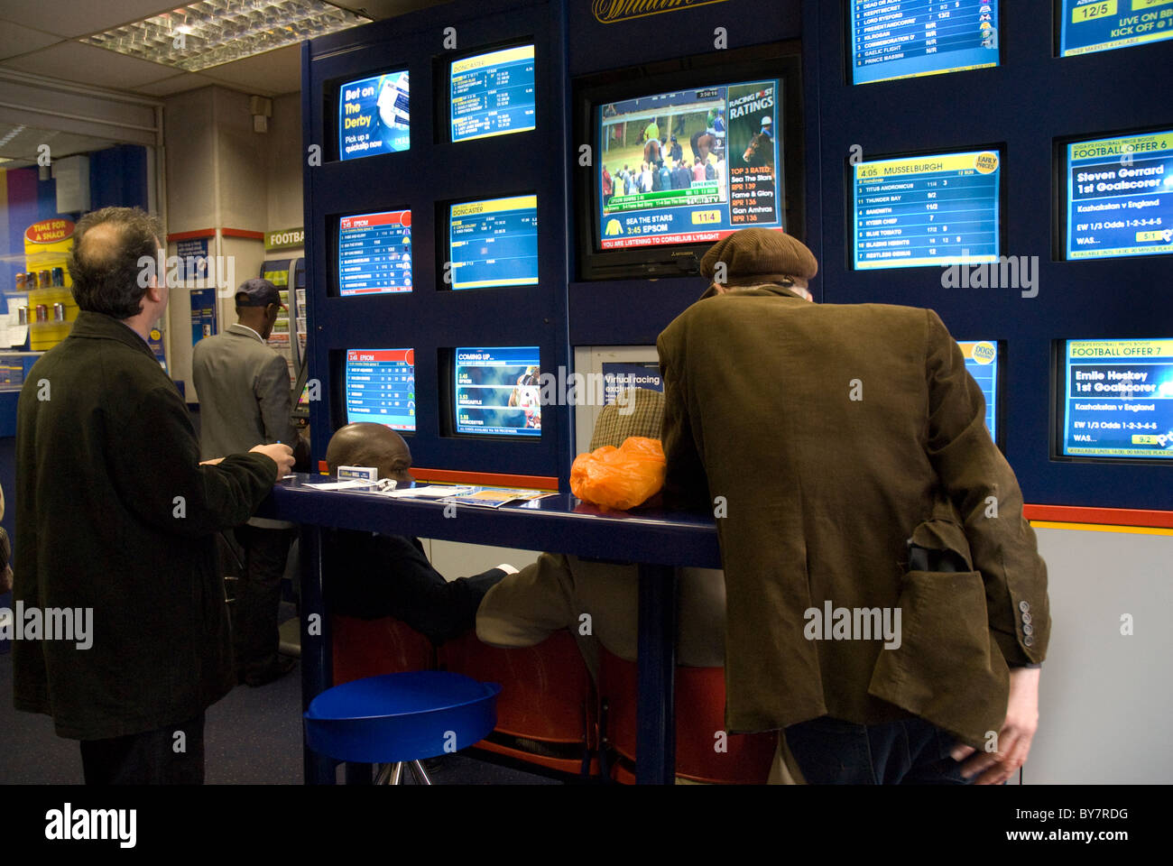 Men putting on betts in bookies Stock Photo