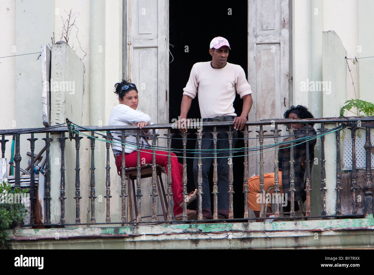 Cuba, Havana. Cubans Observing Life in the Street below their Balcony. Stock Photo