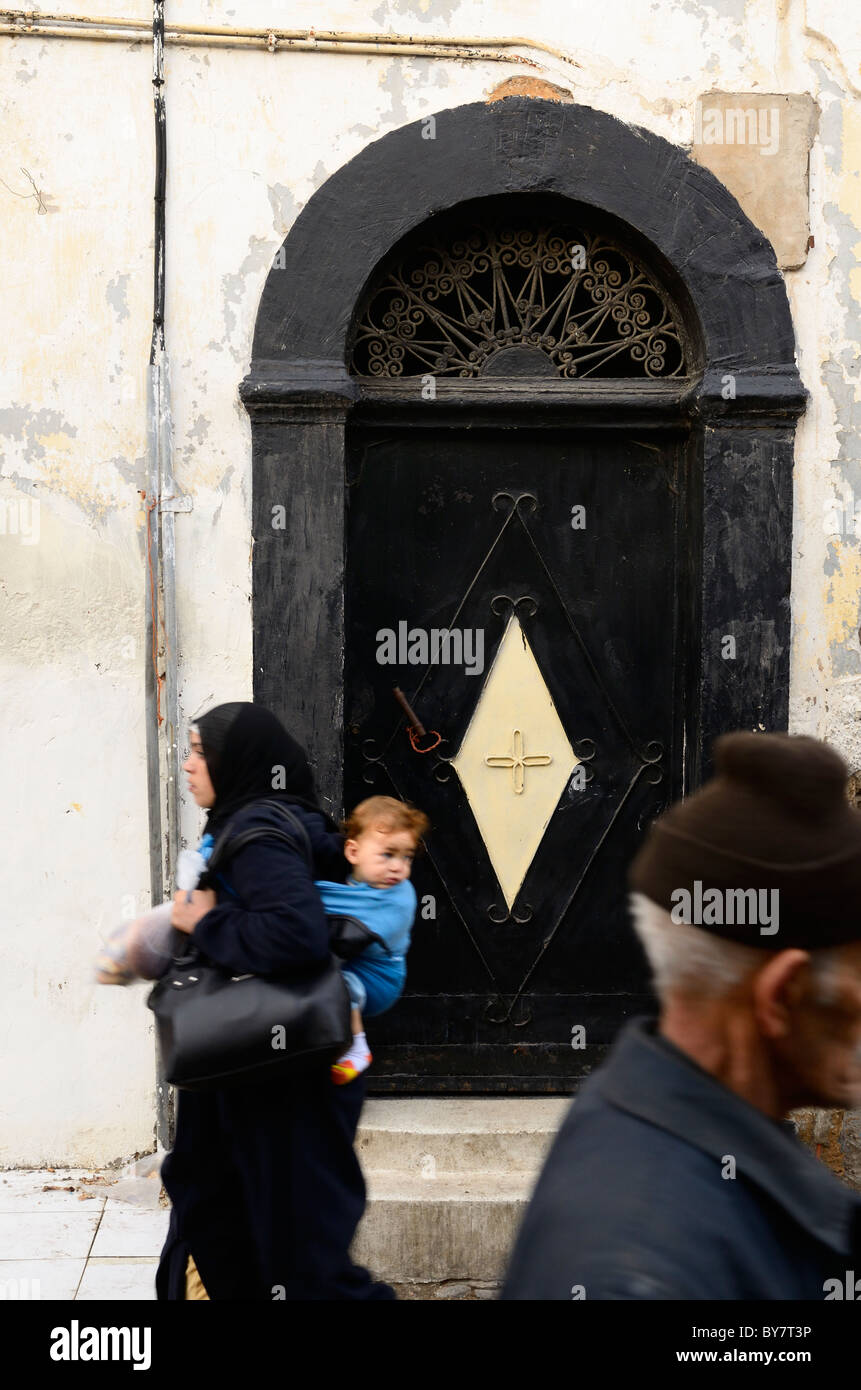 Mother and child and old man walking past a door in the old Medina Casablanca Morocco Stock Photo