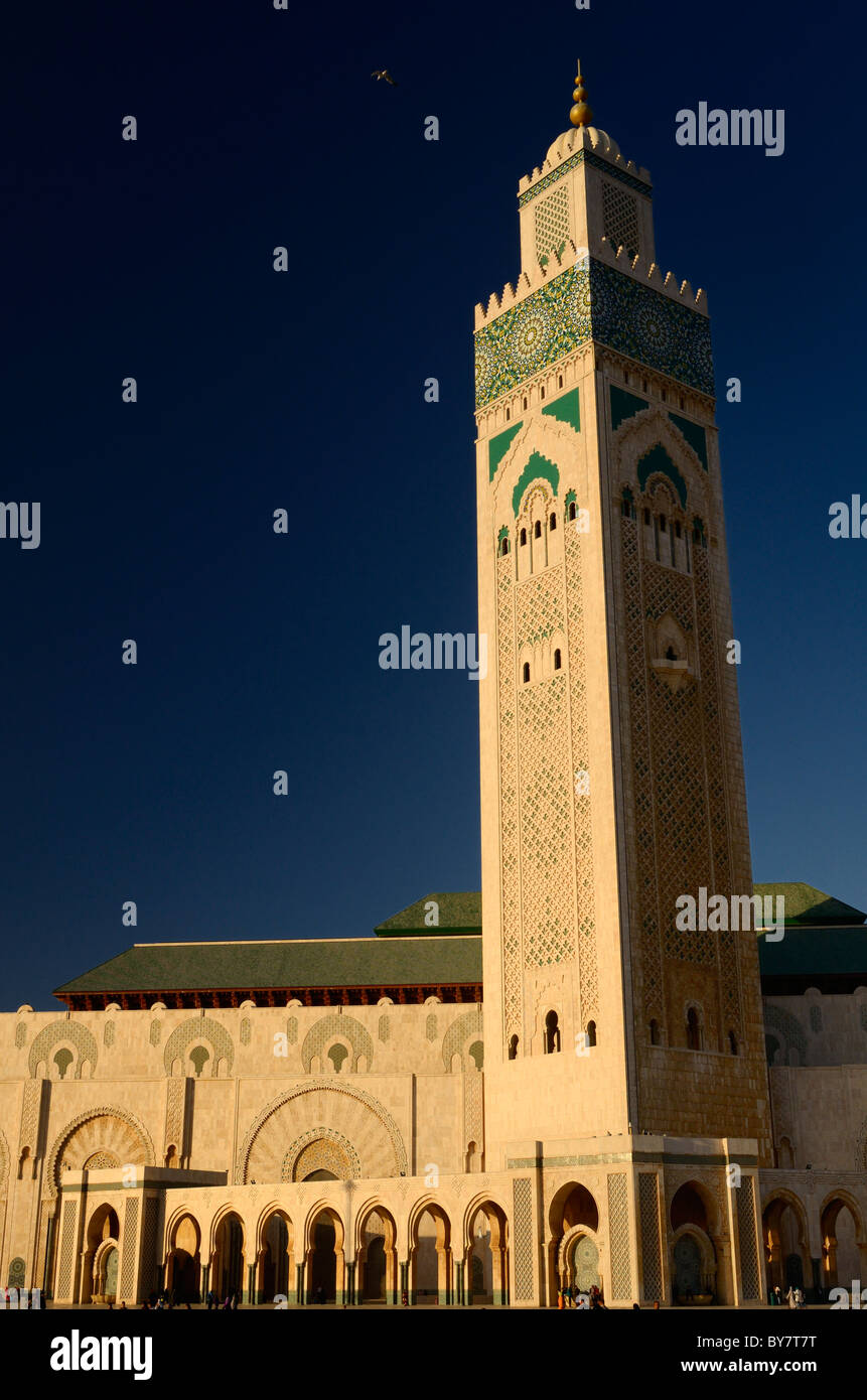 Gold sunshine on worlds tallest Minaret of the Hassan II Mosque in Casablanca Morocco at sunset with blue sky Stock Photo