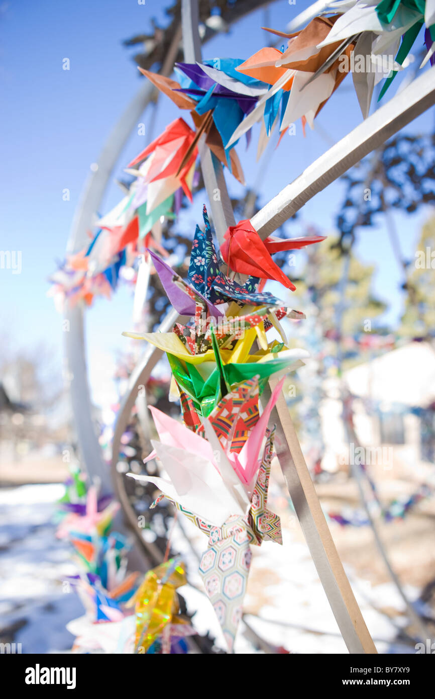Japanese folded origami paper cranes tied to Childrens Peace Statue, New Mexico, USA in memory of Sakako Sasaki Stock Photo