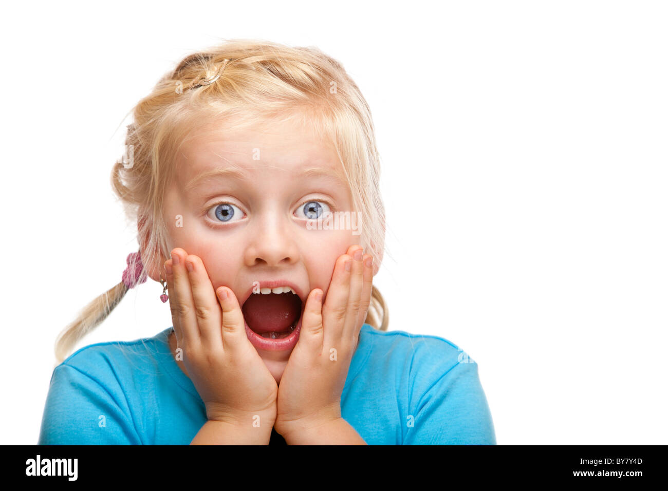 Young blond girl looks shocked at camera. Isolated on white background. Stock Photo