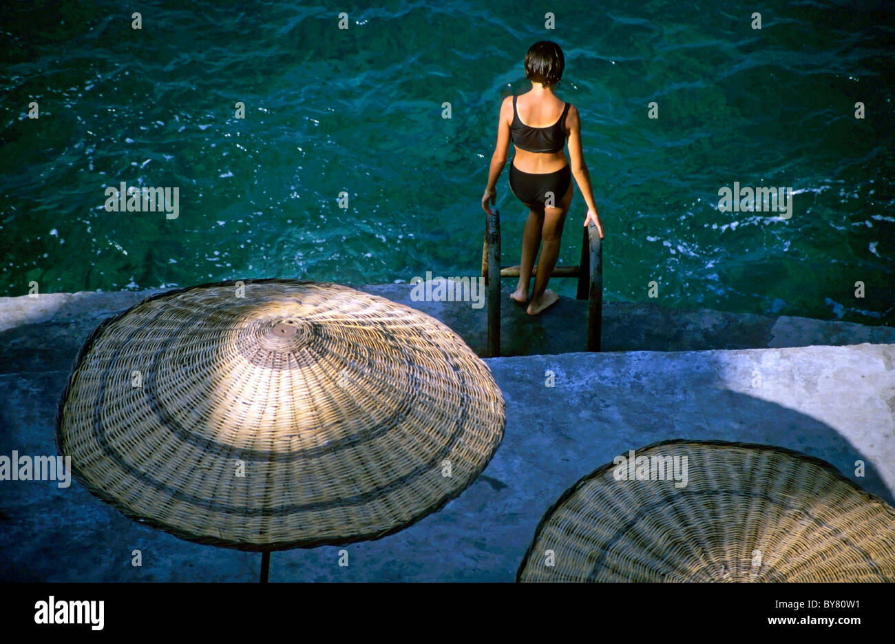 Young woman going swimming in the sea from a hotel, Izmir, Turkey - in the evening. Stock Photo