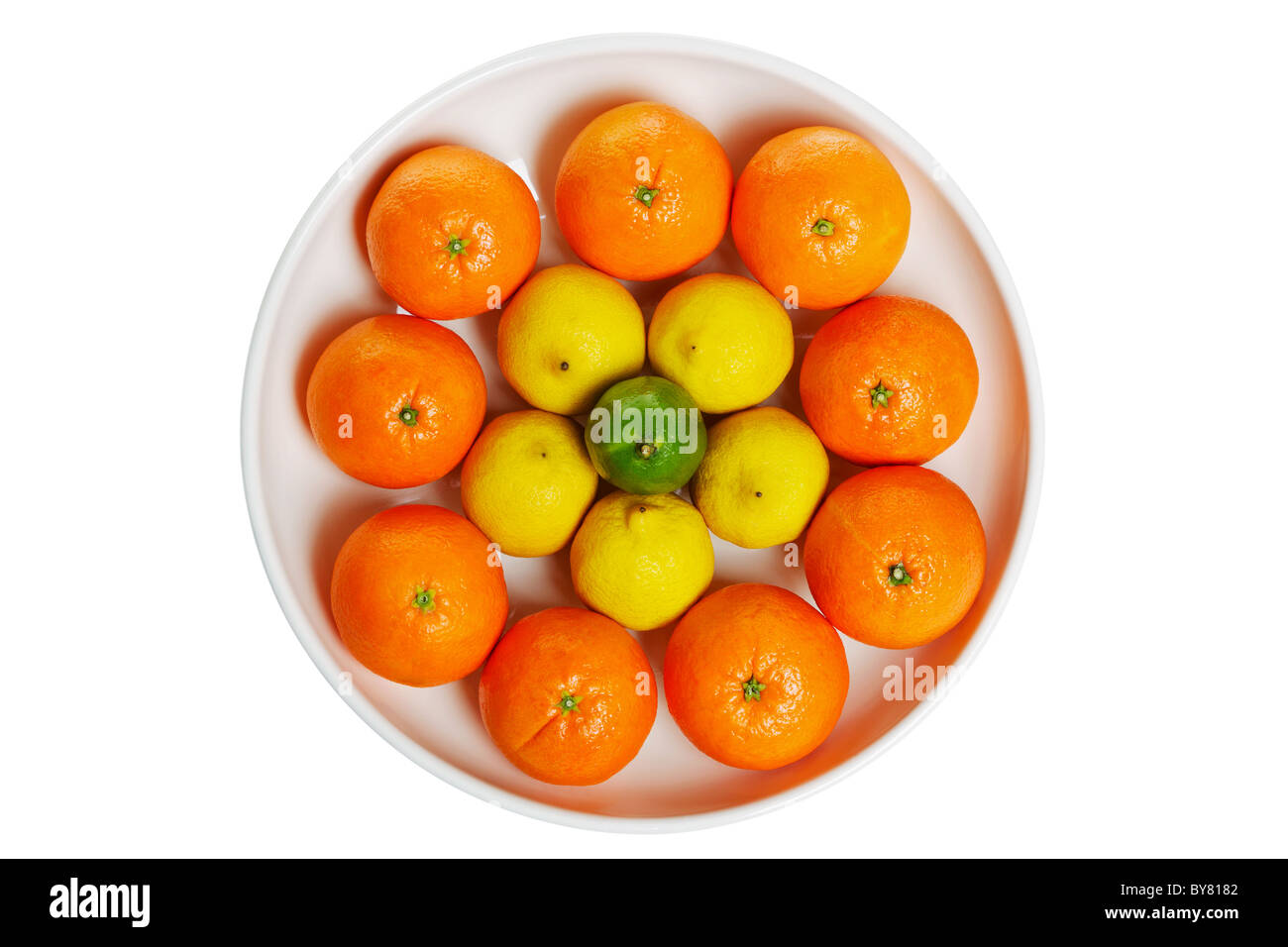 Photo of a bowl full of citrus fruits isolated on a white background, clipping path for the bowl. Stock Photo