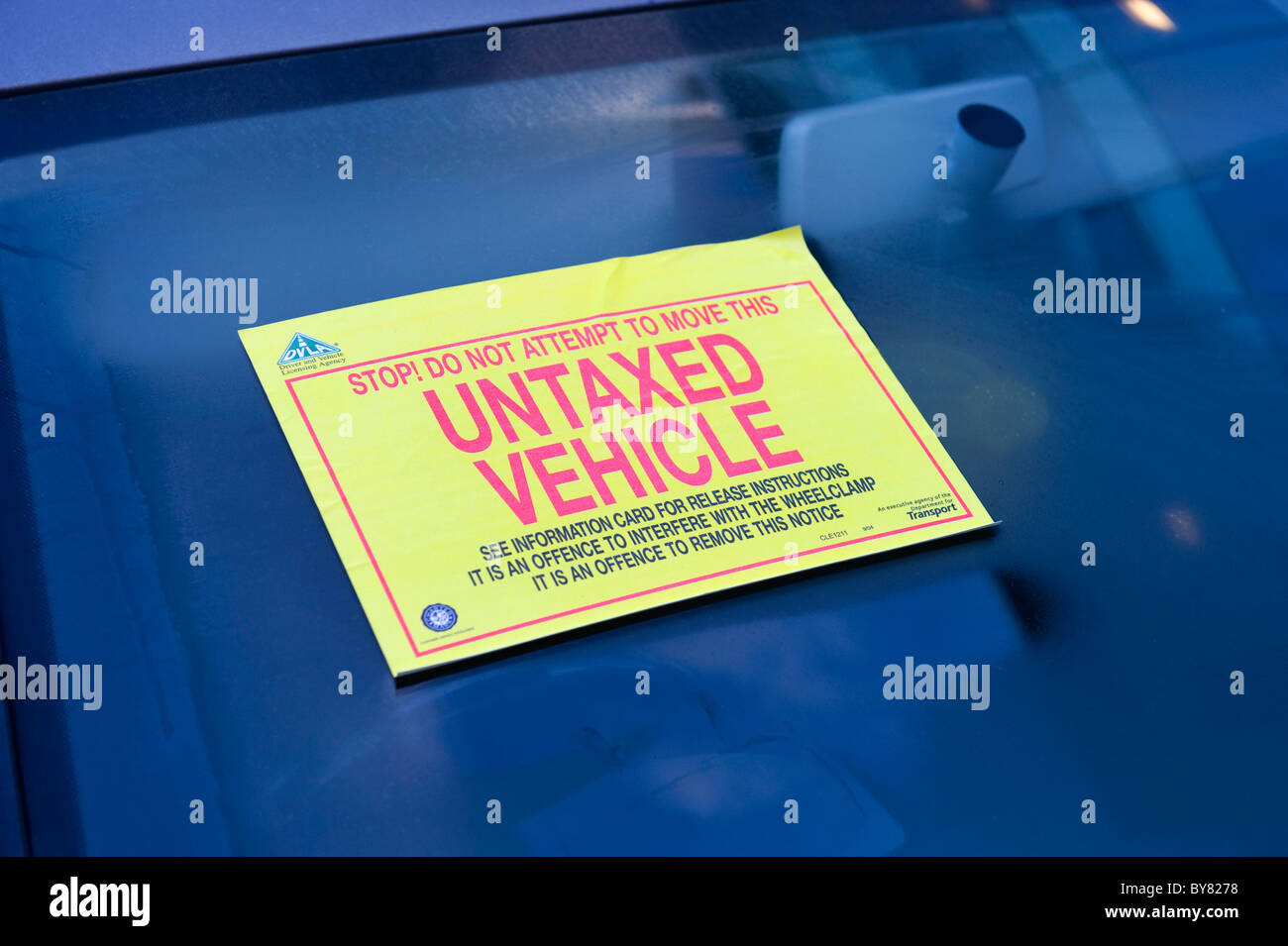 untaxed warning sticker attached to windscreen of vehicle warning not to move clamped vehicle uk Stock Photo