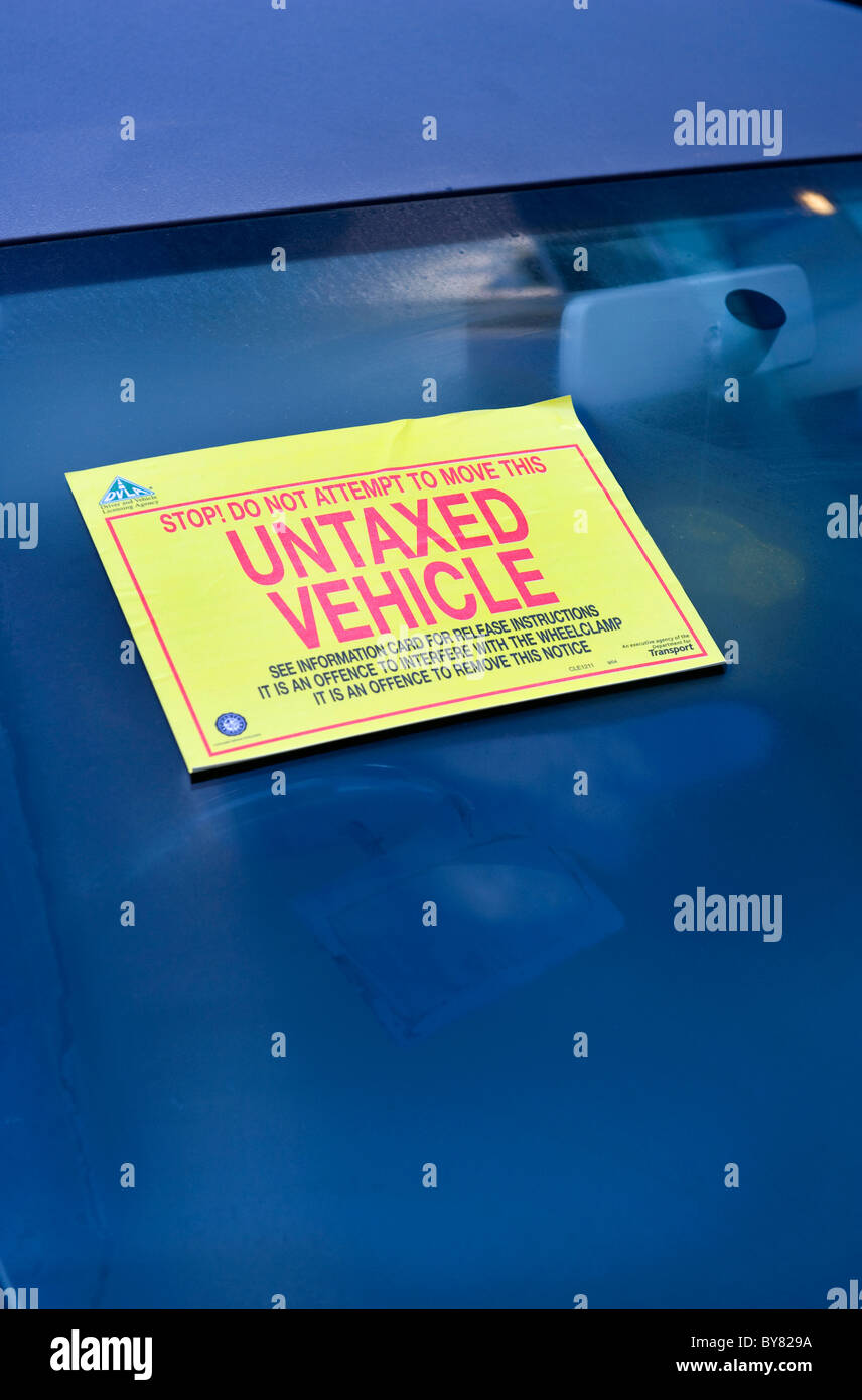 untaxed warning sticker attached to windscreen of vehicle warning not to move clamped vehicle uk Stock Photo