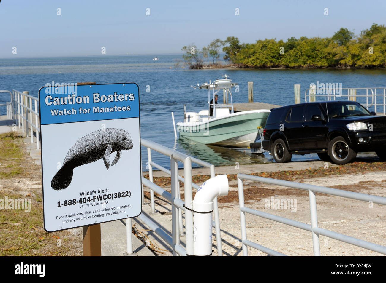 Boat launches into Tampa Bay Florida at Ruskin at Simmons Park with sign caution Manatee area sign as a warning Stock Photo