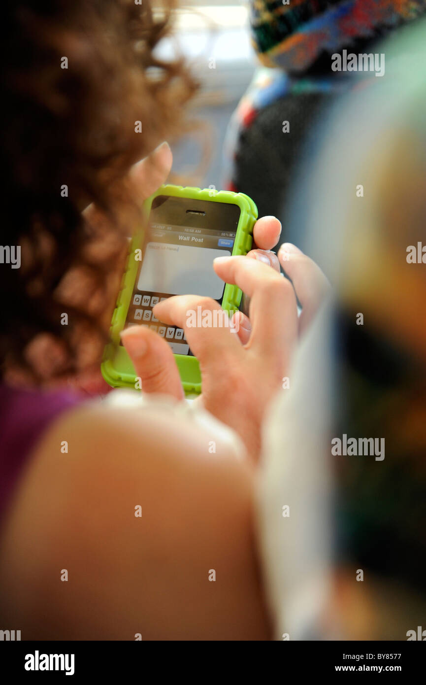 Woman uses handheld electronic device to text email and while