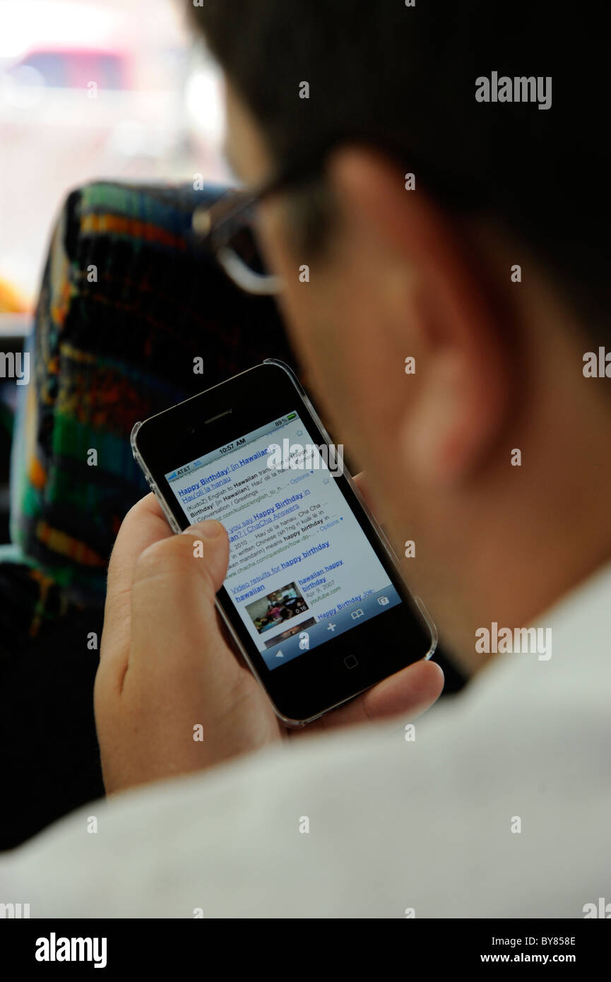 Man uses handheld electronic device to check email and while
