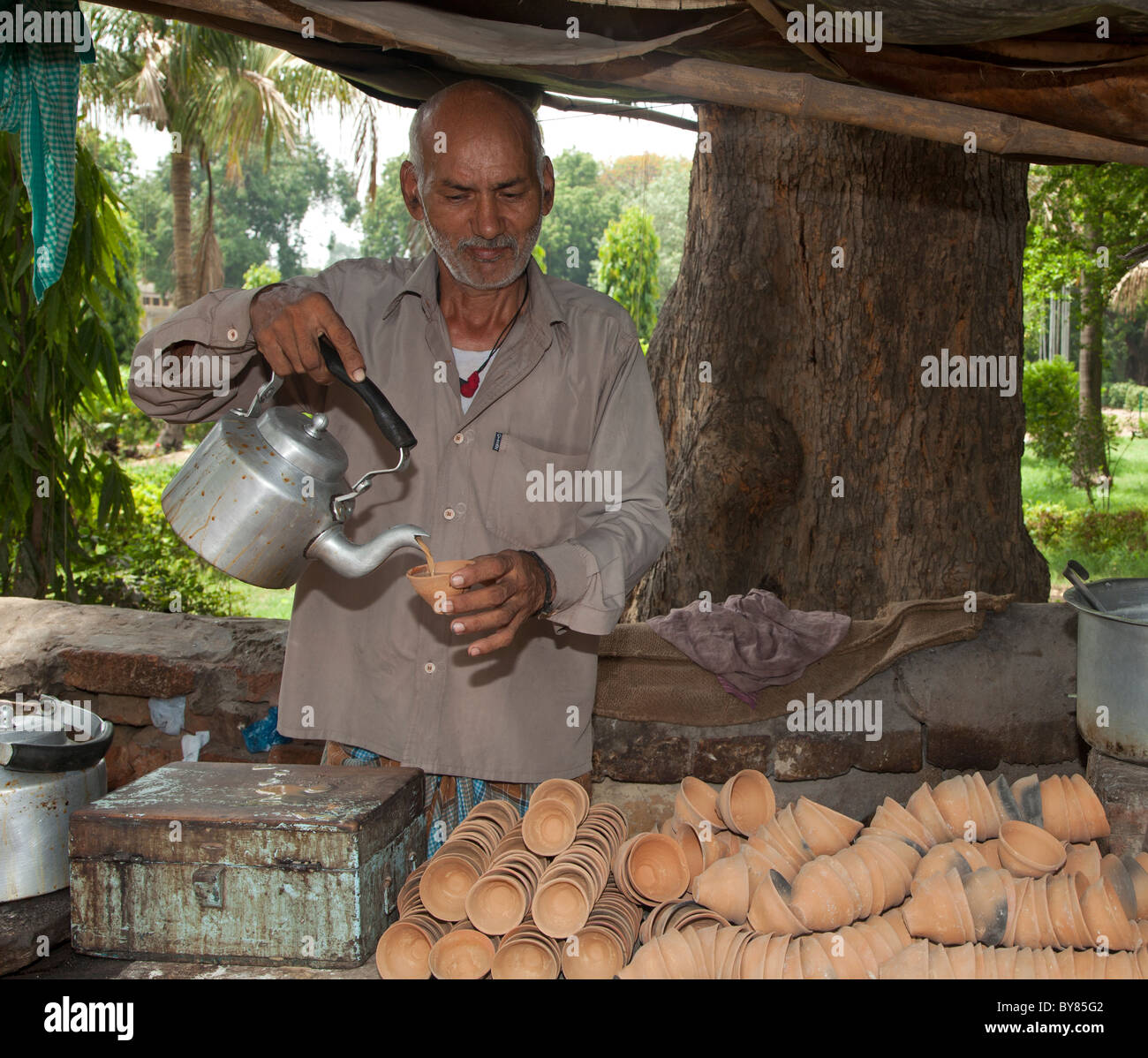 India, Varanasi, Tea (chai) seller using traditional disposable clay pots Stock Photo