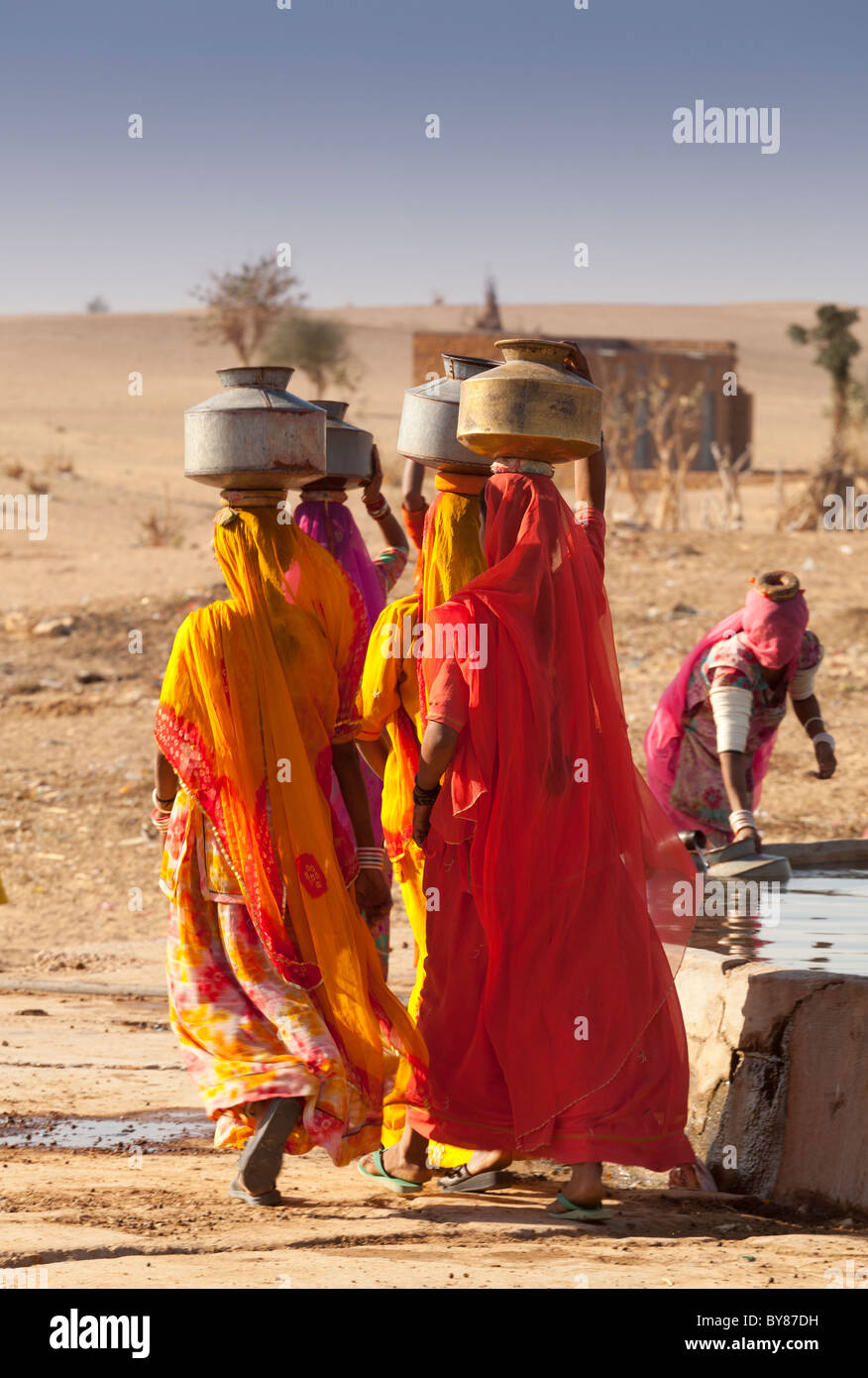India, Rajasthan, women carrying water near village tank Stock Photo