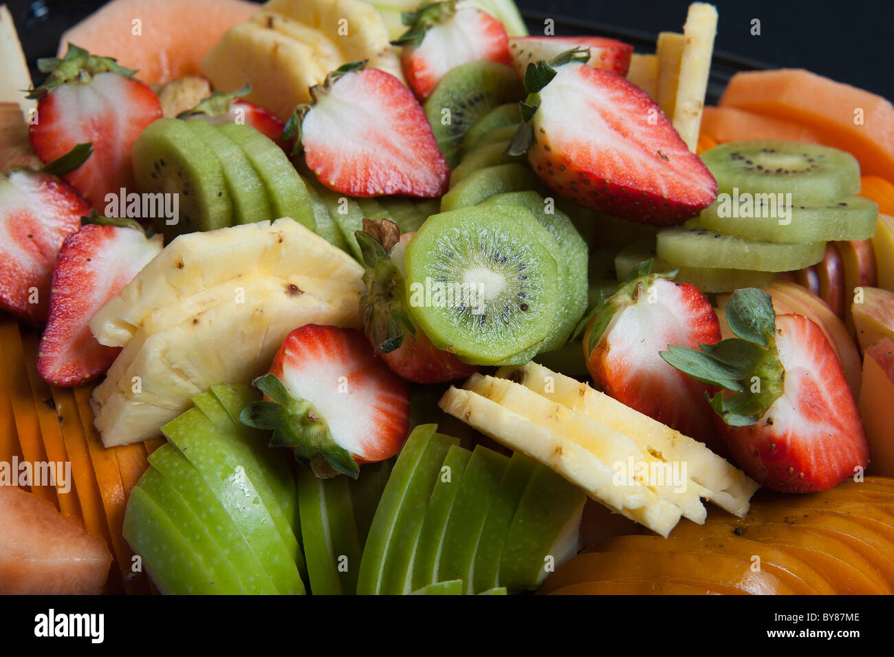 Freshly cut fruit salad with kiwi, pineapple, strawberries and melon Stock Photo