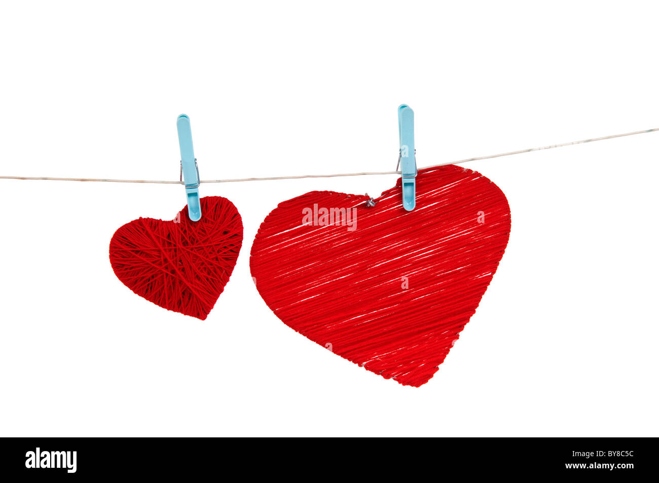 Two red hearts hanging on a rope with pins Stock Photo