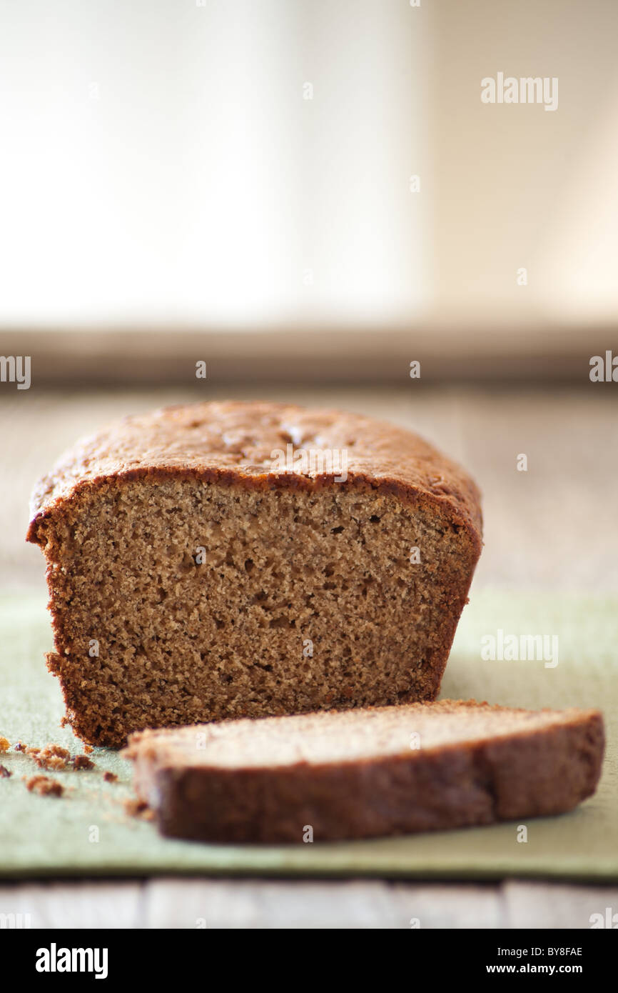 Banana bread with a slice cut on a rustic wooden surface Stock Photo