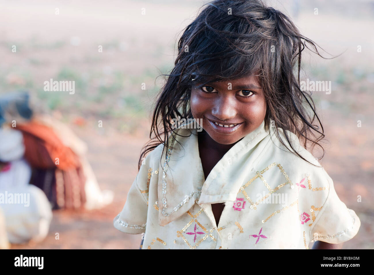 Happy young poor lower caste Indian street girl smiling. Selective focus with copy space Stock Photo