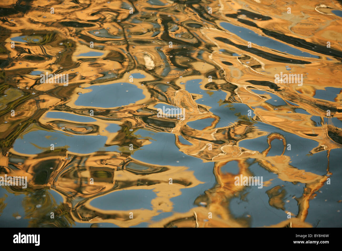 water reflecting golding colors in abstract patterns Stock Photo