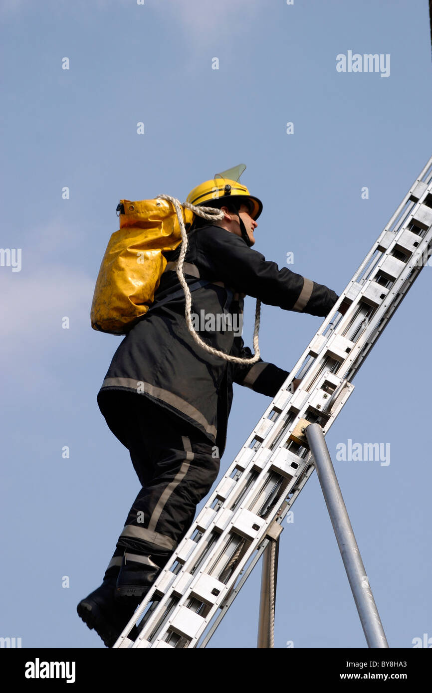Firefighter climbs a ladder Stock Photo Alamy
