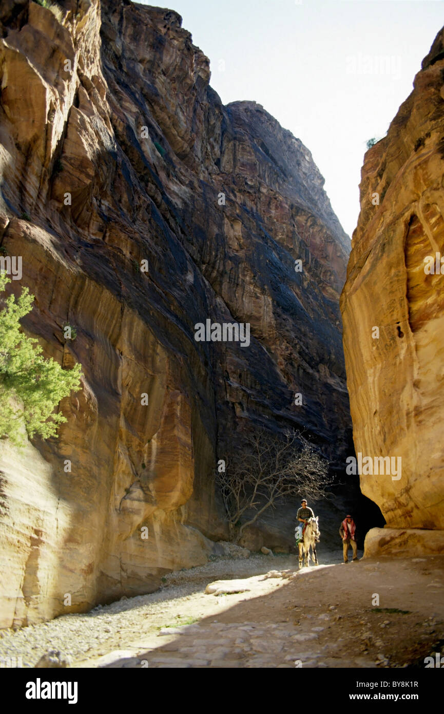 Man riding a horseman and a Bedouin coming out the Siq Canyon, Petra, Jordan. Stock Photo