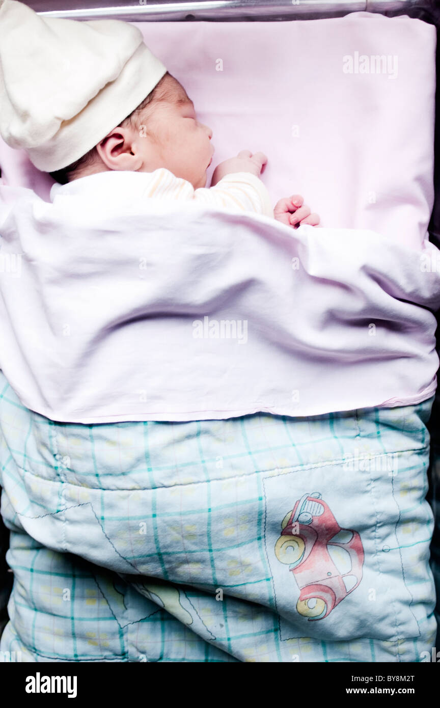 Newborn Baby In Hospital One Day Old With Cap Sleeping In His Crib