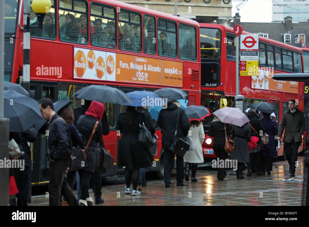 A Queue Of People Waiting In The Rain To Board A Bus In The London Morning Rush Hour At Waterloo London Stock Photo Alamy