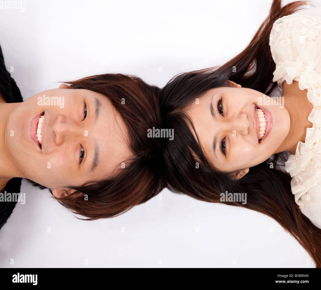 Happy asian couple laying on white floor Stock Photo - Alamy