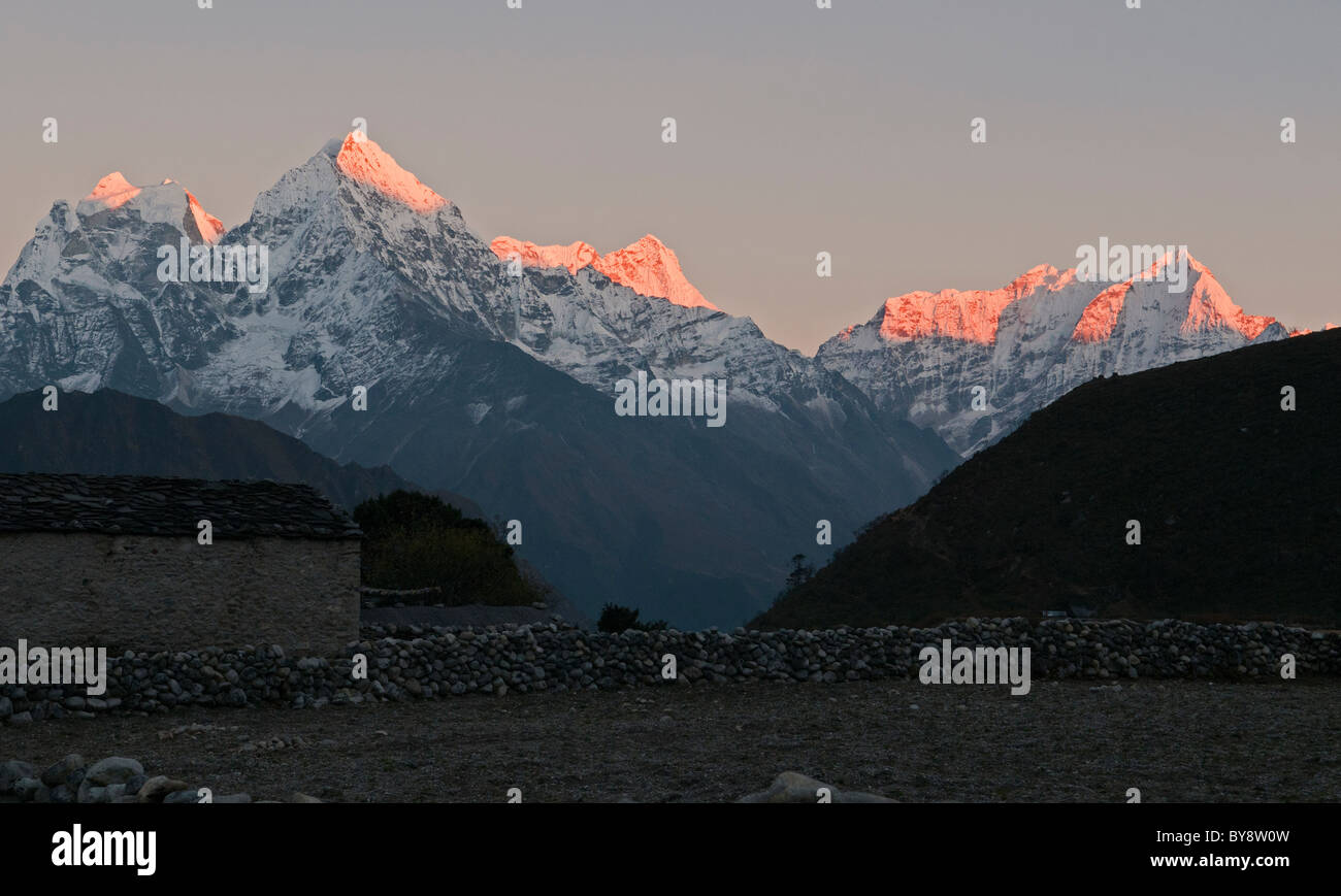 sunset over Thamserku and Kusum Kangeru peaks in the Everest Region of Nepal Stock Photo