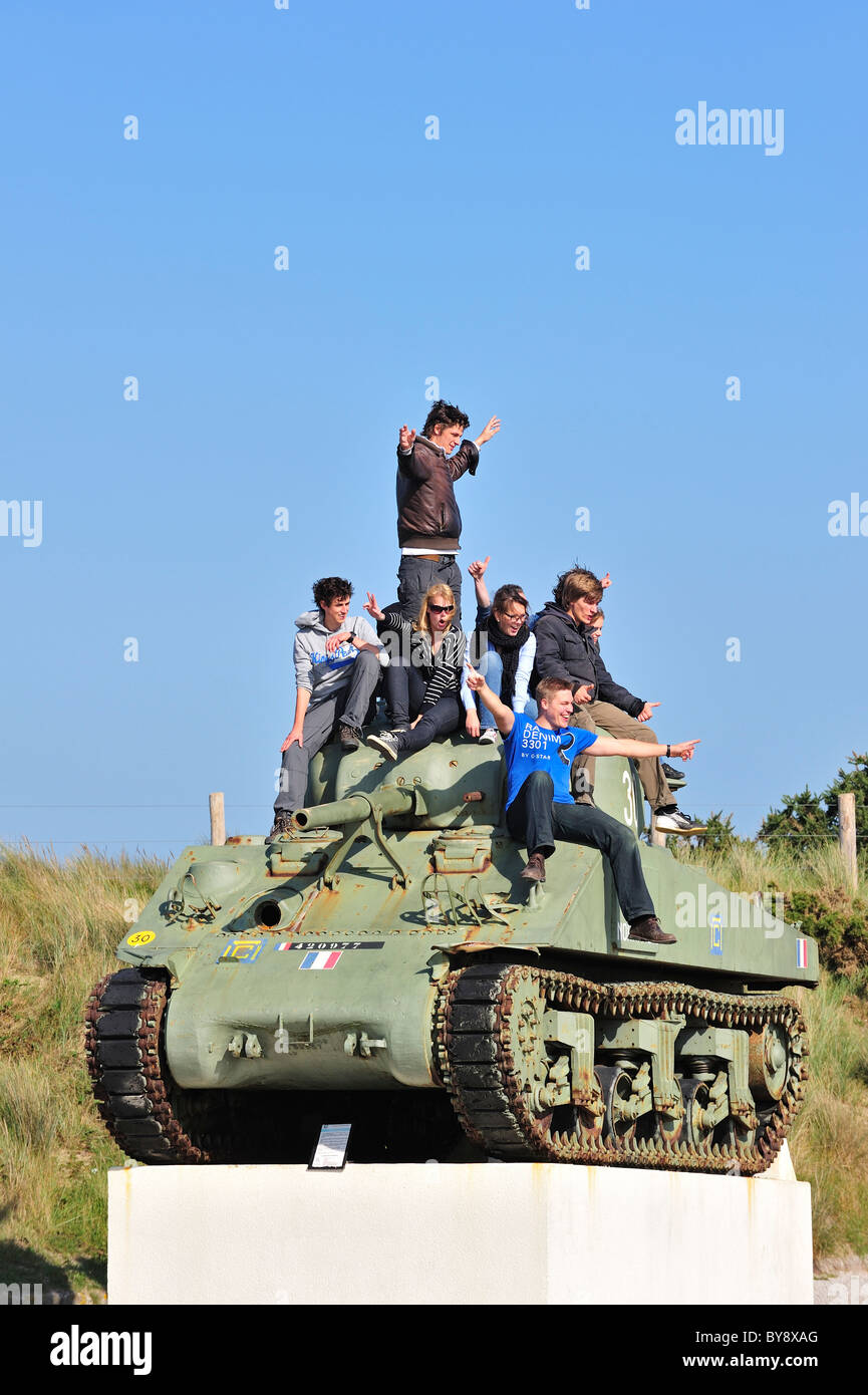 Teenagers on Second World War Two American Sherman tank as WW2 monument near Utah Beach, Normandy, France Stock Photo