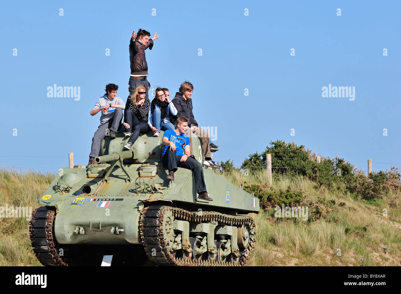 Teenagers on Second World War Two American Sherman tank as WW2 monument near Utah Beach, Normandy, France Stock Photo
