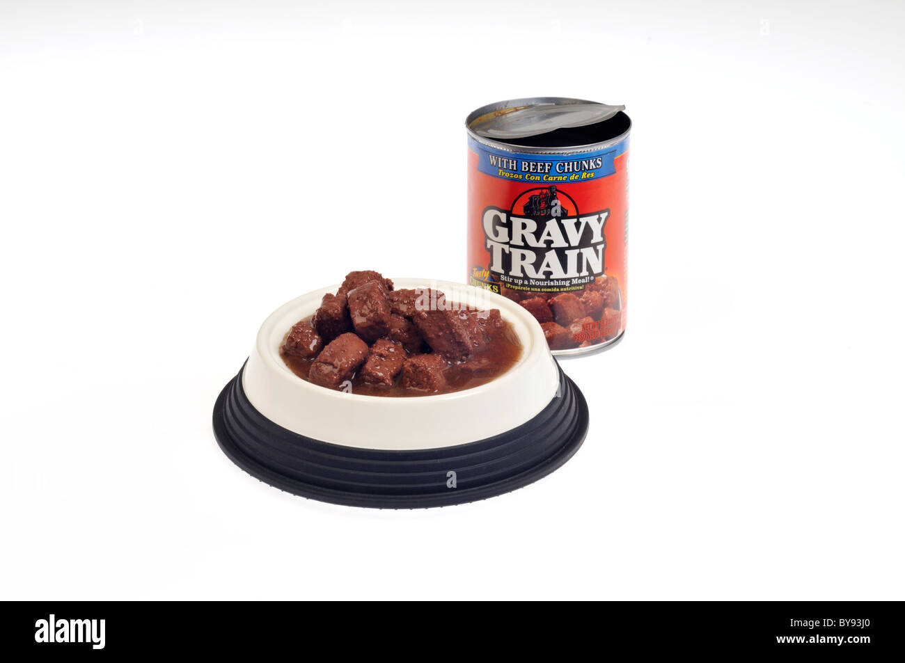 Bowl of Gravy Train meaty dog food in gravy with open can on white background, cut out. Stock Photo