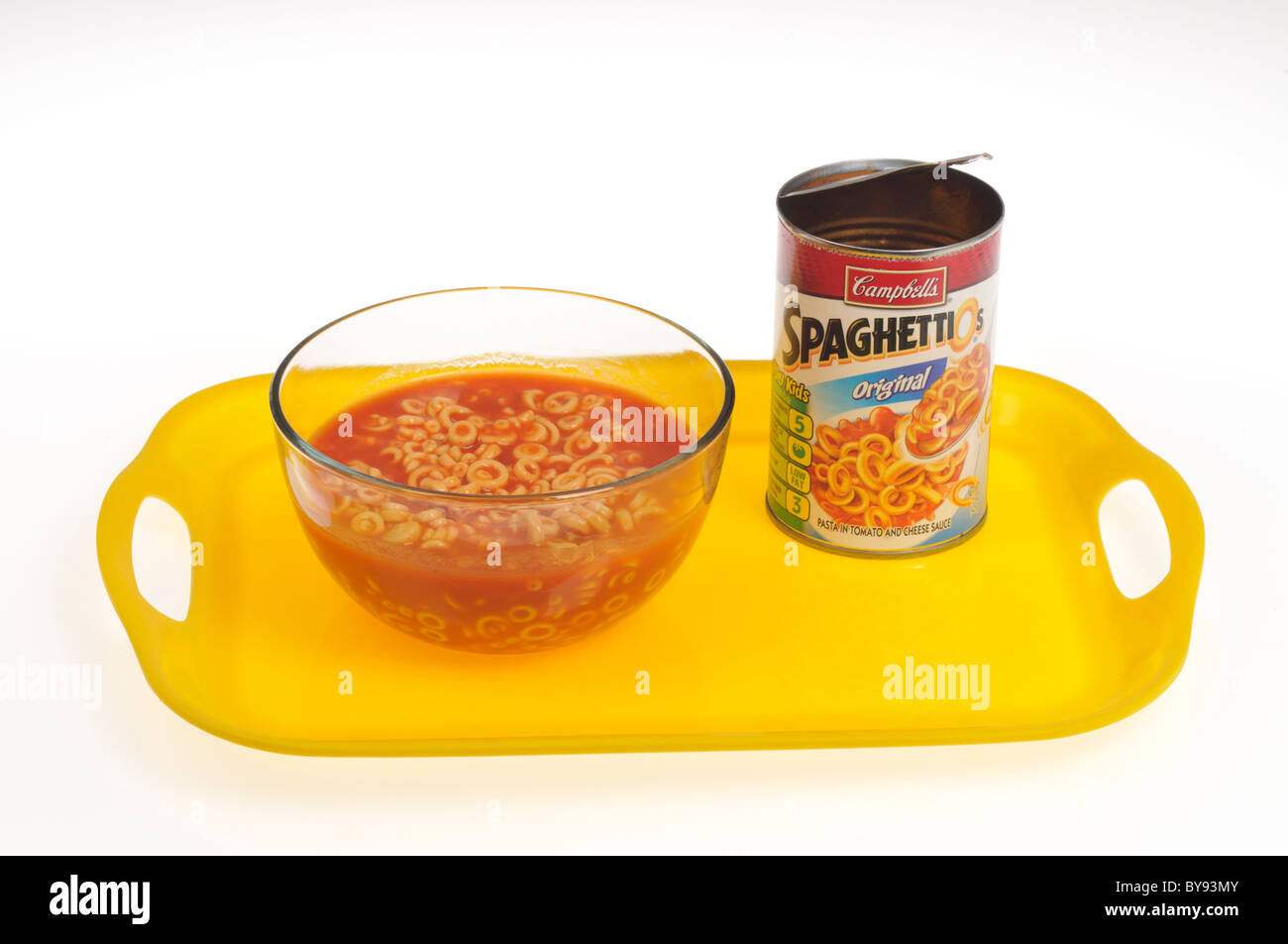 Bowl of Spaghetti-O's with tomato  sauce on tray with open can of Spaghetti-O's on white background, cut out. Stock Photo