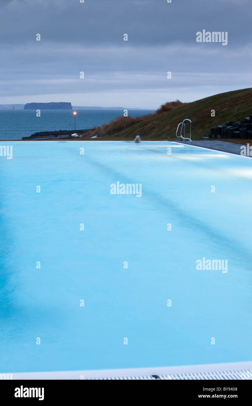 The outdoor swimming pool in the small village of Hofsos, Iceland, overlooks the island Drangey. Stock Photo