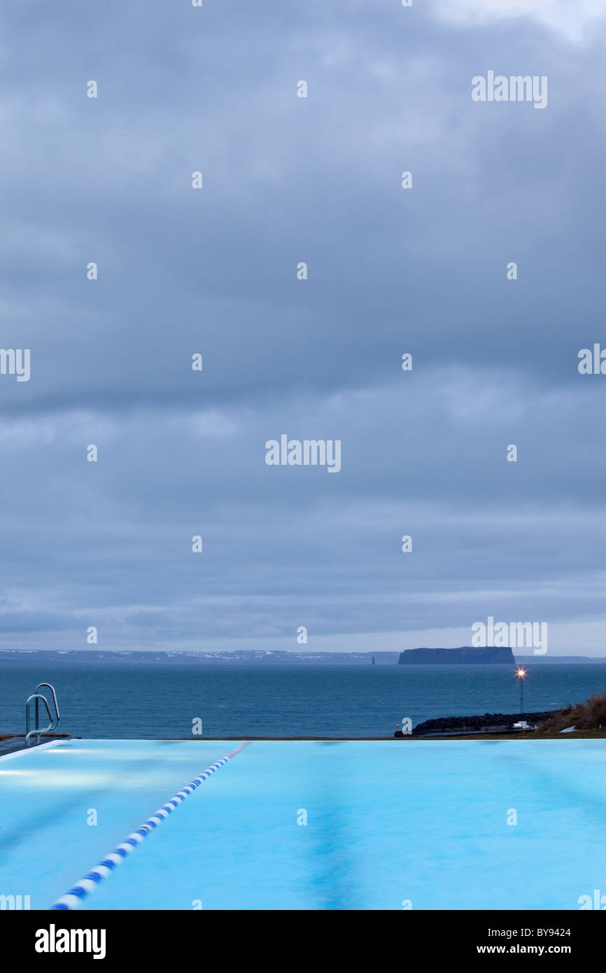 The outdoor swimming pool in the small village of Hofsos, Iceland, overlooks the island Drangey. Stock Photo