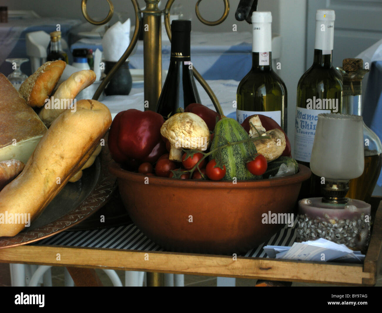 Bottles of wine & food displayed on a table in a restaurant on the Greek Island of Santorini in the Aegean Sea Stock Photo