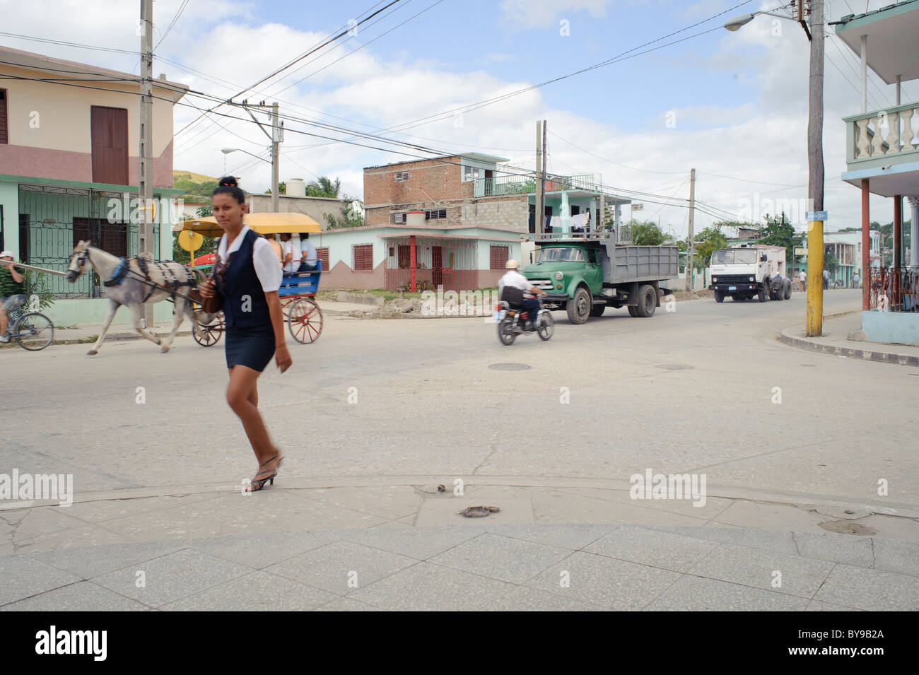 Street view at a cross road in Holguin Cuba with trucks carriage and  woman in uniform Stock Photo