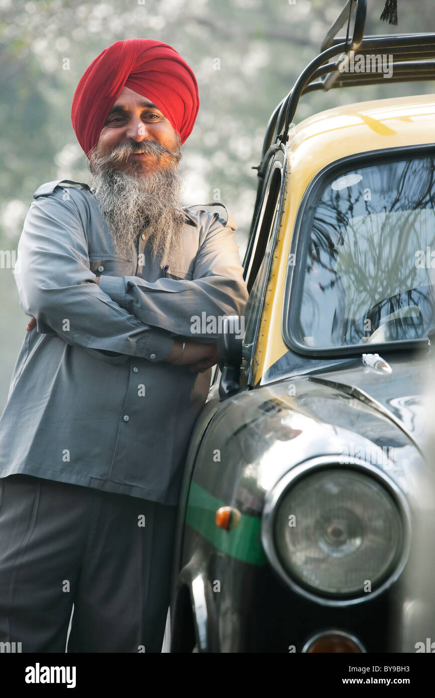 Sikh taxi driver standing next to his vehicle Stock Photo