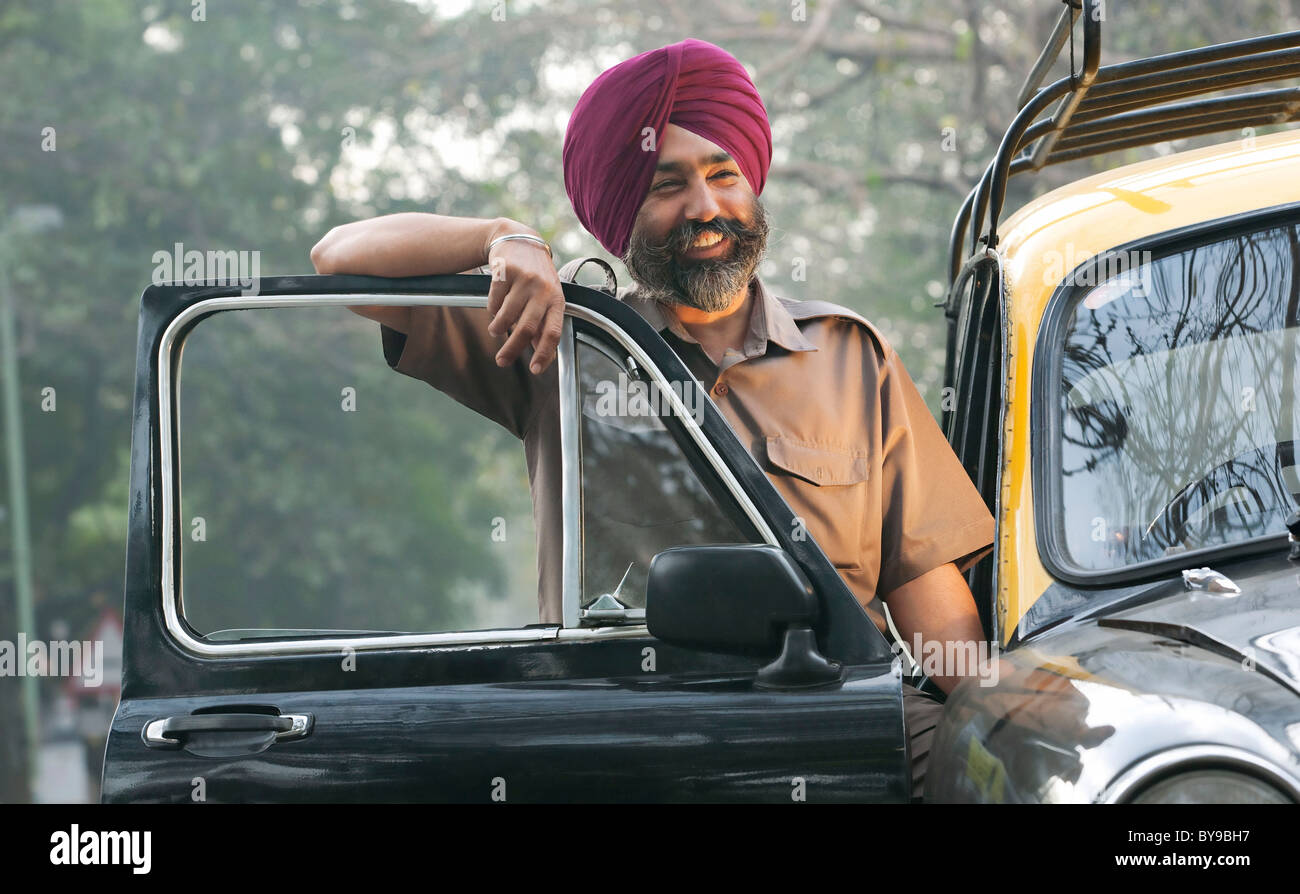Sikh taxi driver standing next to his vehicle Stock Photo