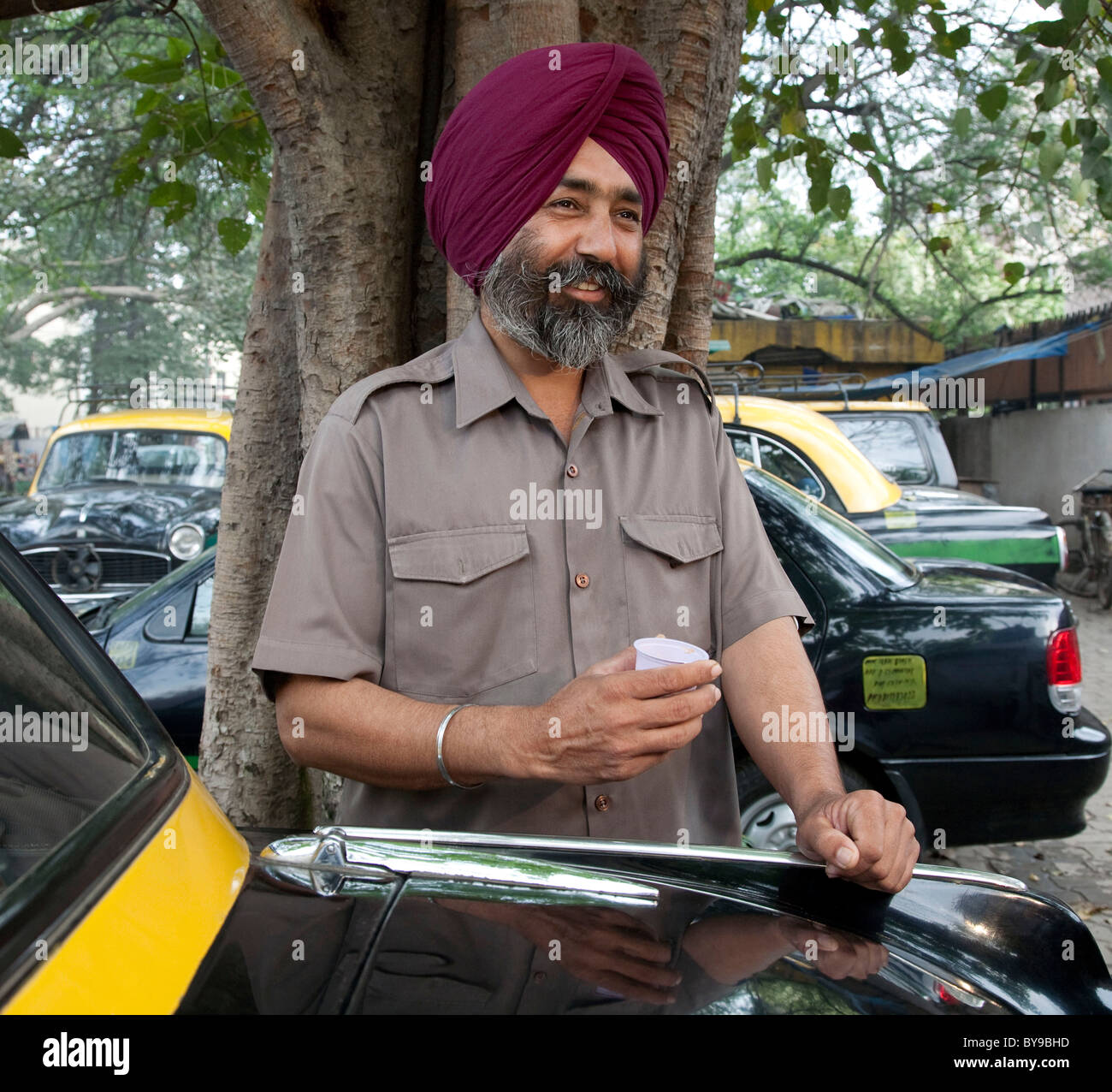 Sikh man standing next to his taxi Stock Photo