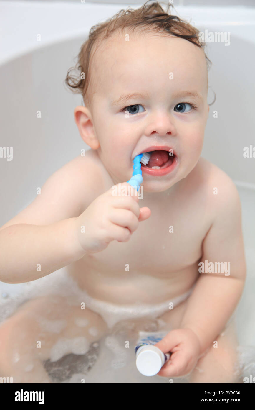 Baby boy brushing his teeth in the bath Stock Photo Alamy