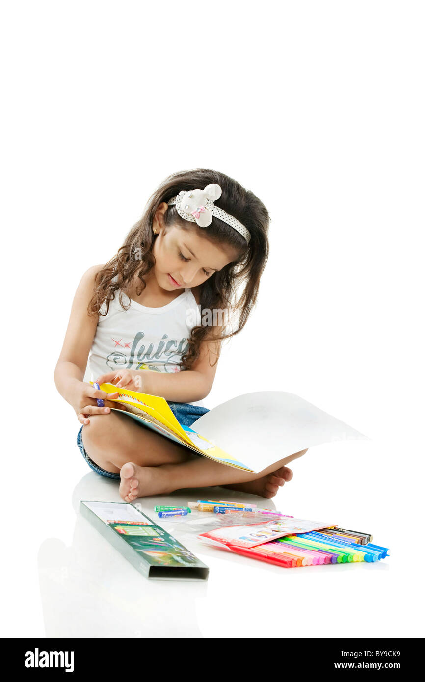 Girl looking at a colouring book Stock Photo