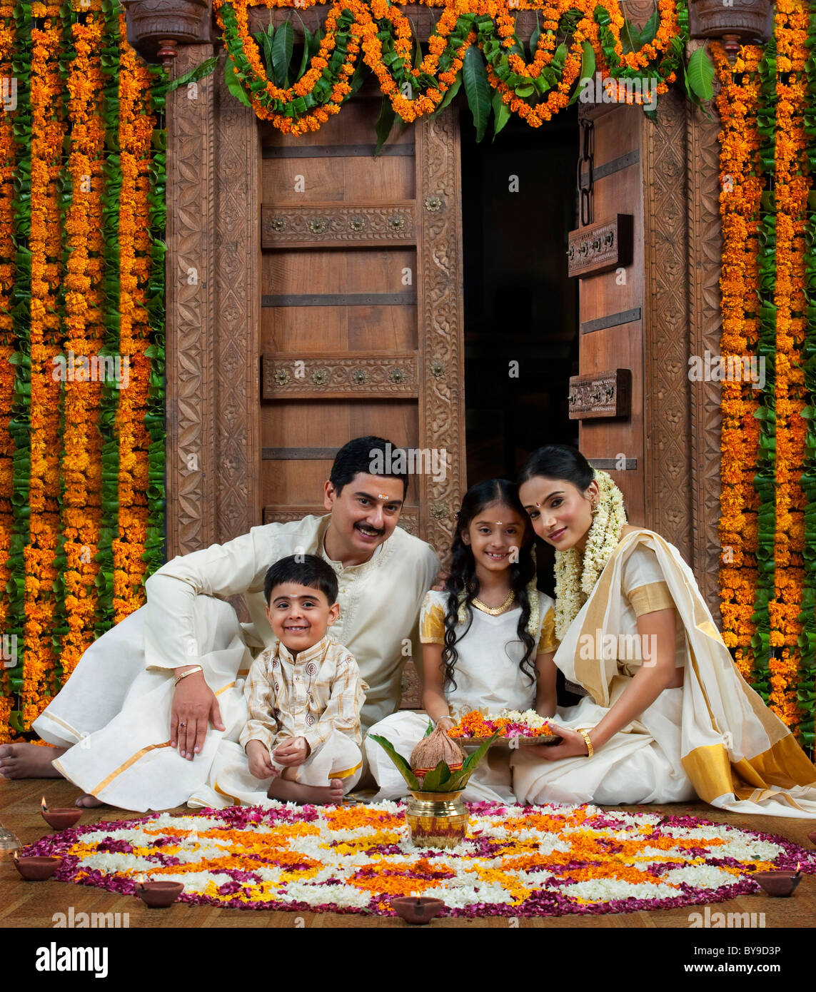 South Indian family with flower rangoli Stock Photo - Alamy