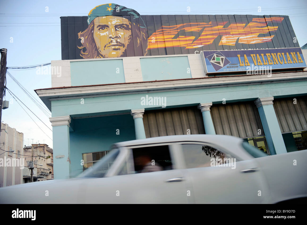Old Classic american car passing with a Poster of Che Guevara on a Building, in a street of Cienfuegos, cuba. Stock Photo