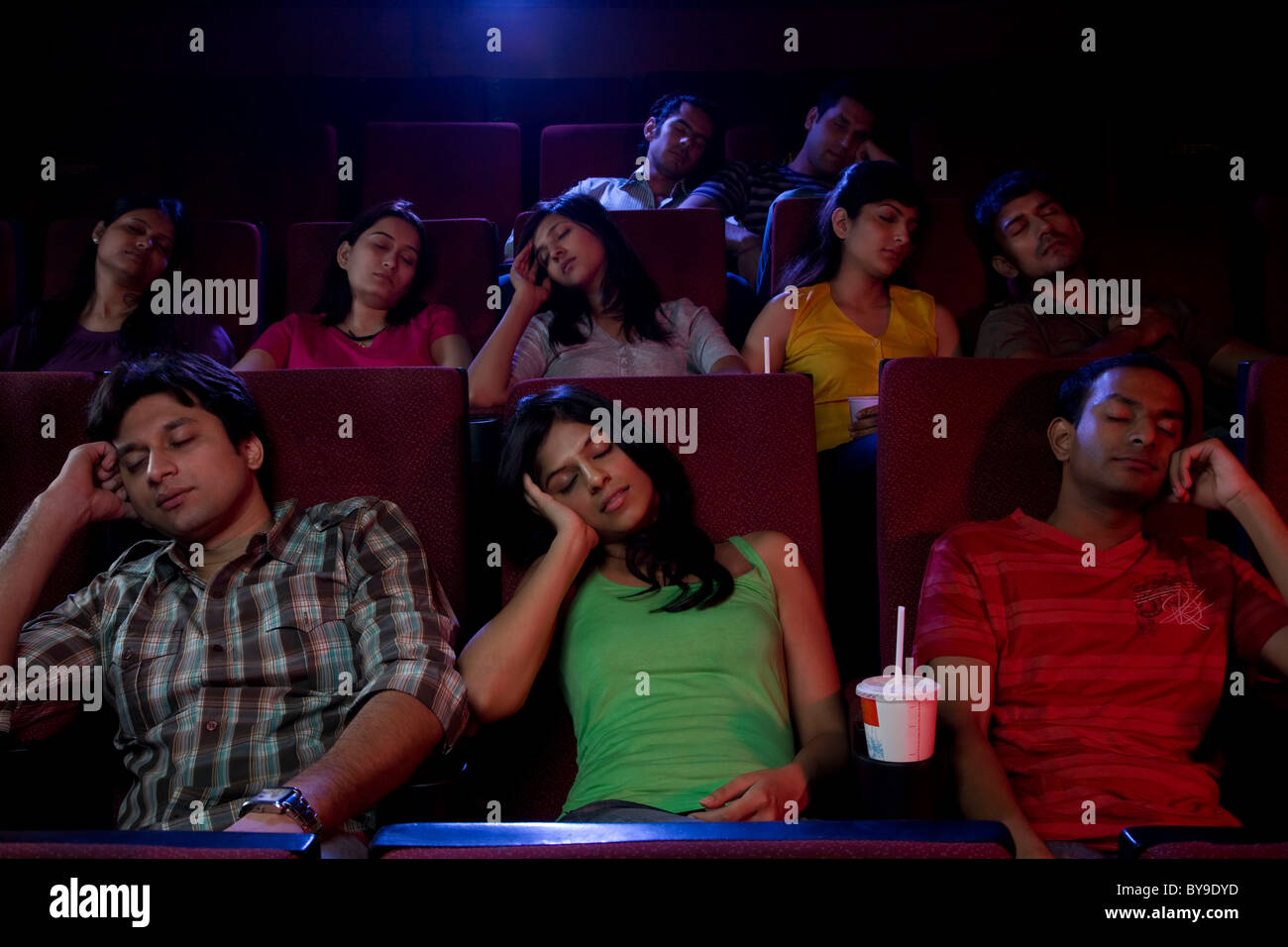 People sleeping inside a cinema hall Stock Photo