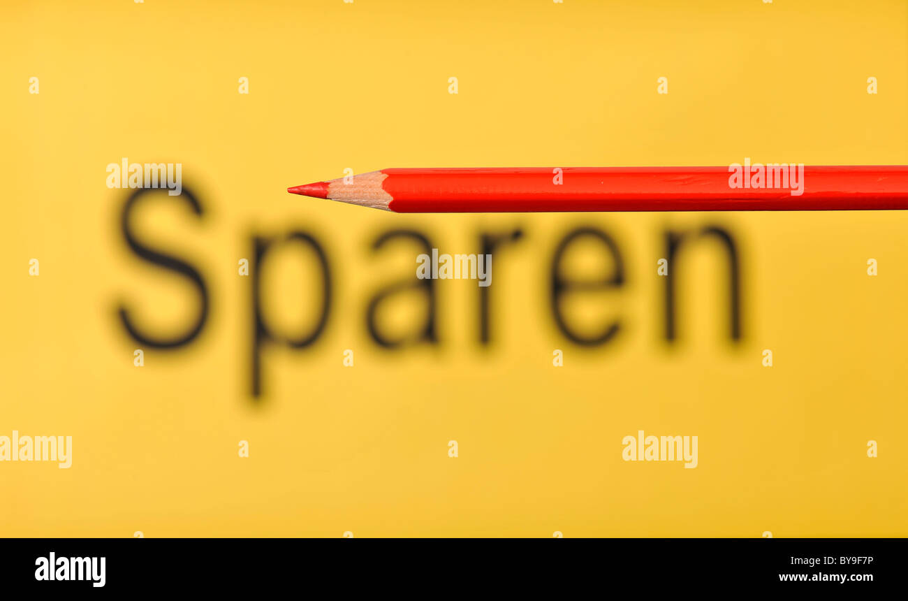 Red pencil in front of the out of focus word Sparen, German for Saving Stock Photo