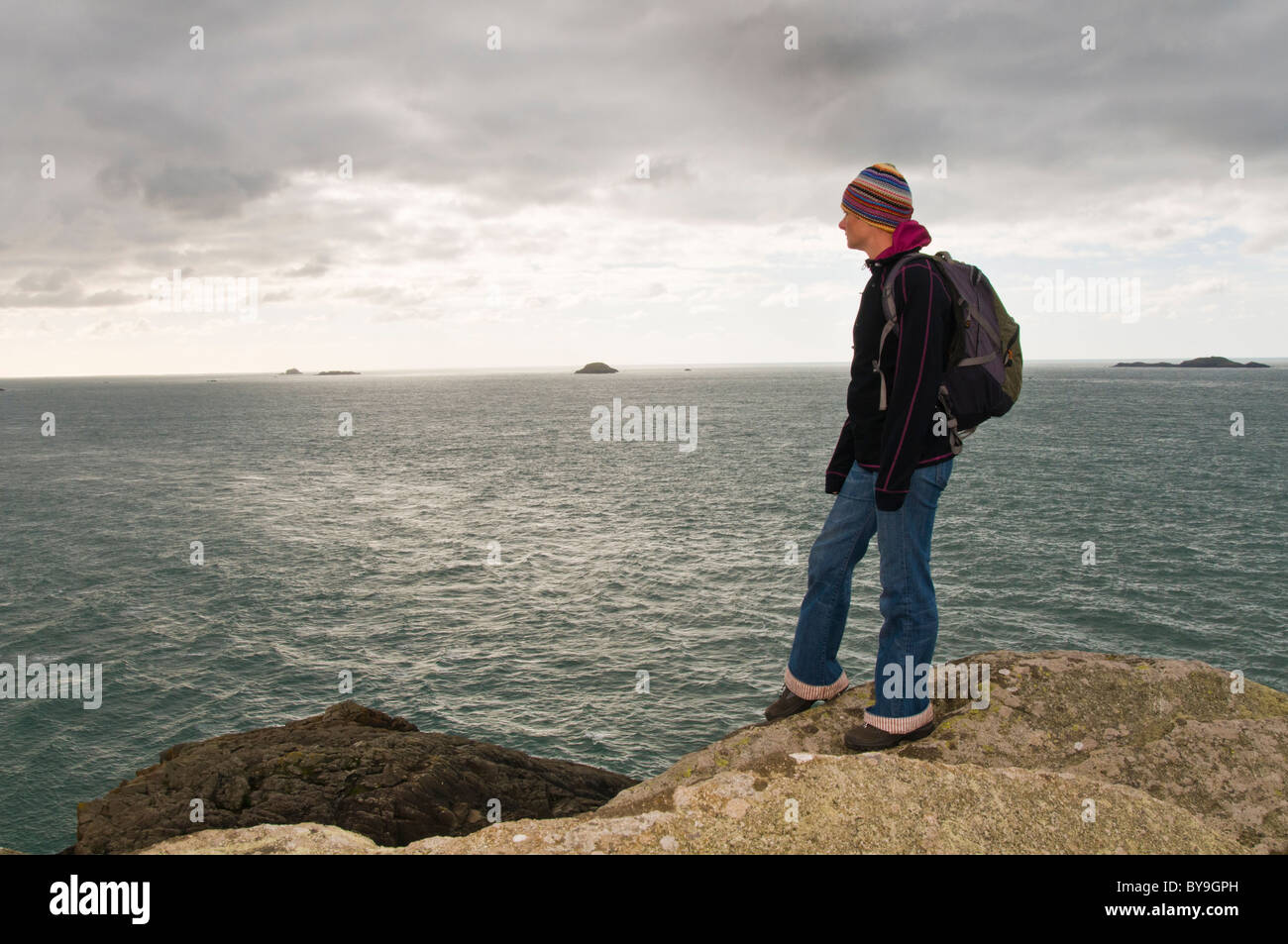 Woman standing on cliff in Pembrokeshire Stock Photo