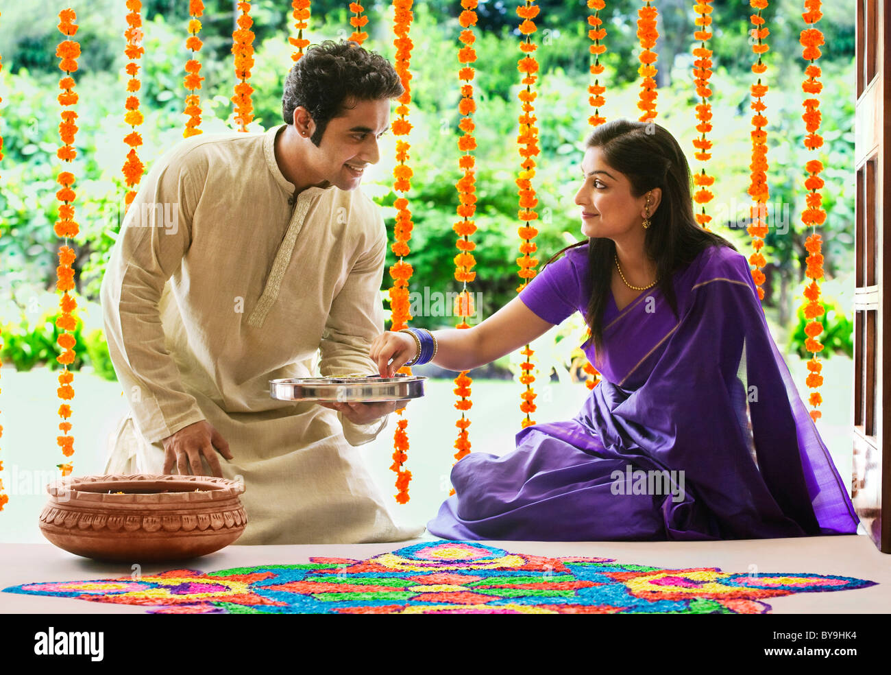 Couple making a rangoli Stock Photo - Alamy
