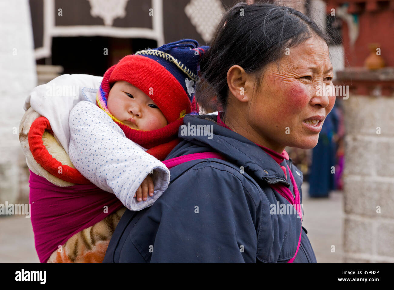 Tibetan woman mother with baby in papoose on her back in the Barkhor ...